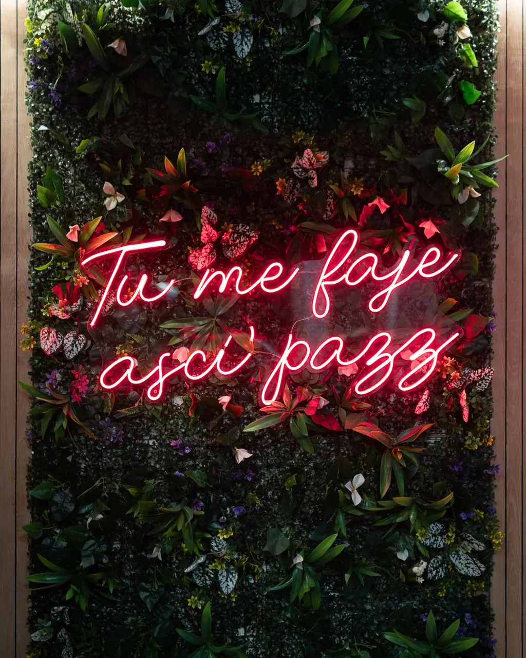 Insegna al neon su parete di fiori e verde all'interno del Tropicana