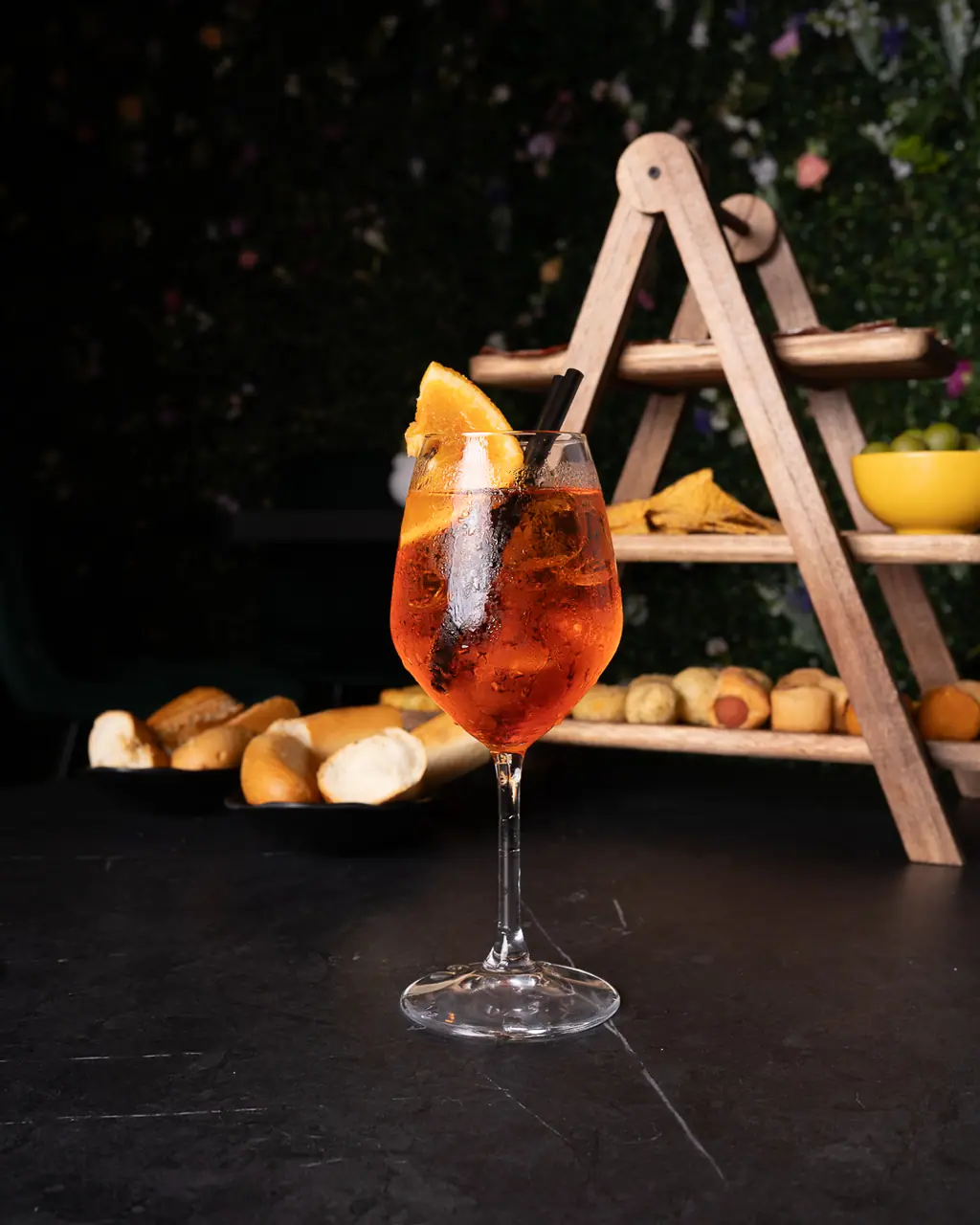Aperol Spritz con un tagliere sullo sfondo, luce calda